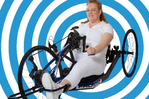 Vrouw op handbike: een aangepaste fiets voor mensen met een fysieke beperking.