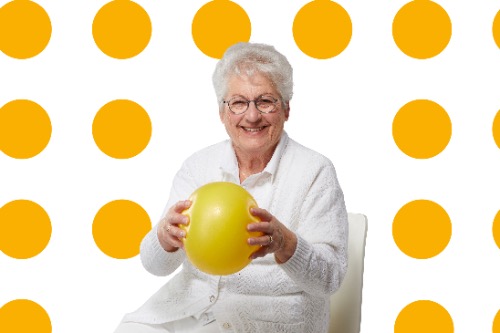 Campagnebeeld GO Waalwijk: oudere dame met bal doet beweegoefening